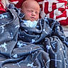 baby, newborn, blanket, wrapped, sleeping, face, infant, cozy, soft, red, white, gray, pattern, arrow, fleece, resting, peaceful, closeup, portrait, child