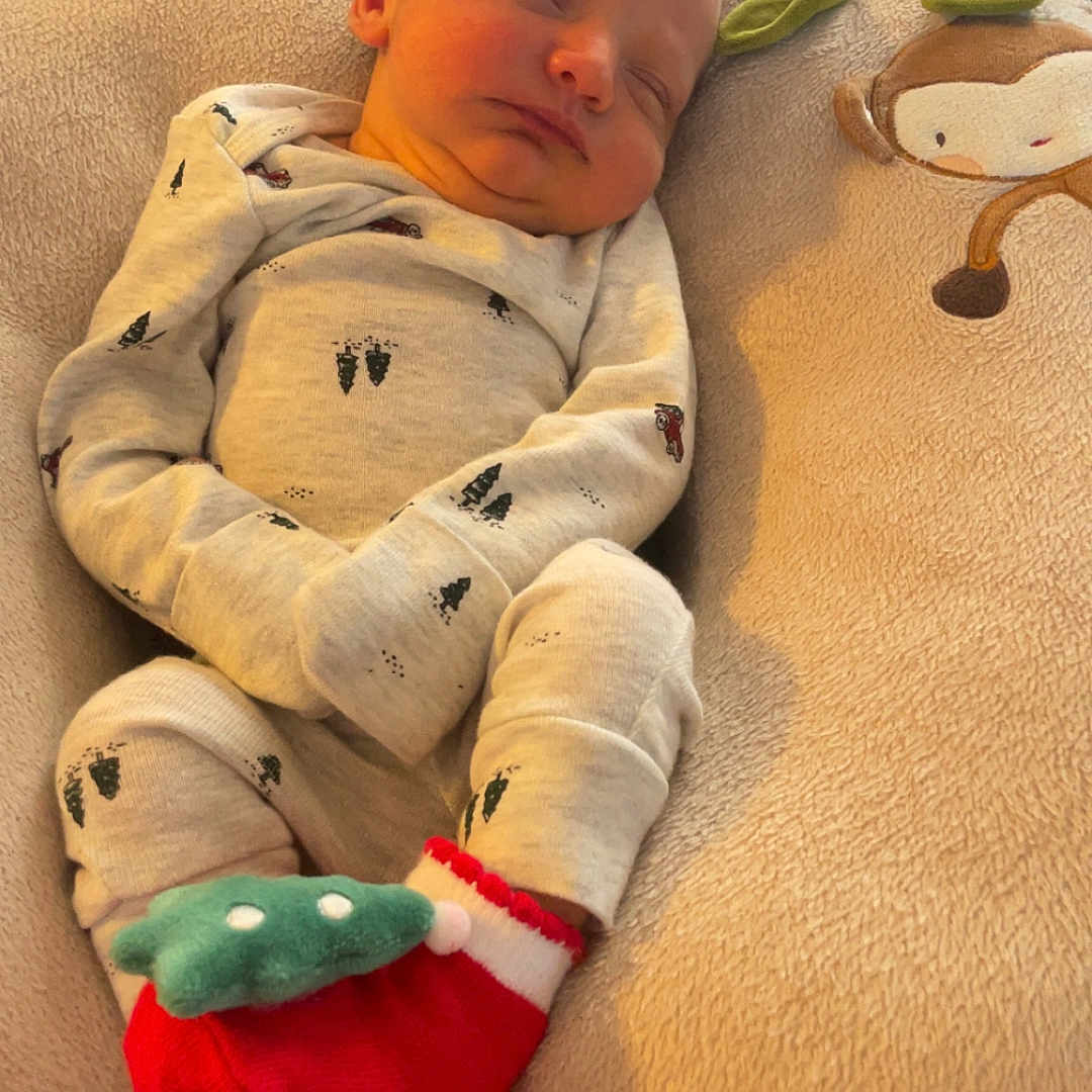 Remi joined the competition — help win amazing prizes! baby, blanket, child, closeup, comfort, cozy, cute, green_accents, home, indoor, infant, monkey_design, newborn, pajamas, peaceful, portrait, red_socks, resting, sleeping, soft_cushion