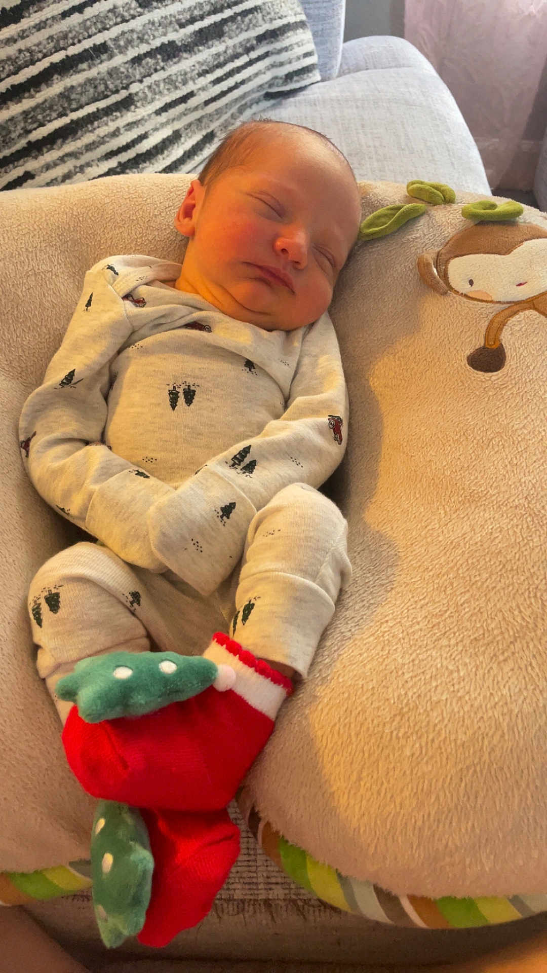 Remi joined the competition — help win amazing prizes! newborn, baby, sleeping, pajamas, red_socks, green_accents, soft_cushion, monkey_design, cozy, indoor, infant, cute, resting, child, home, blanket, comfort, peaceful, portrait, closeup