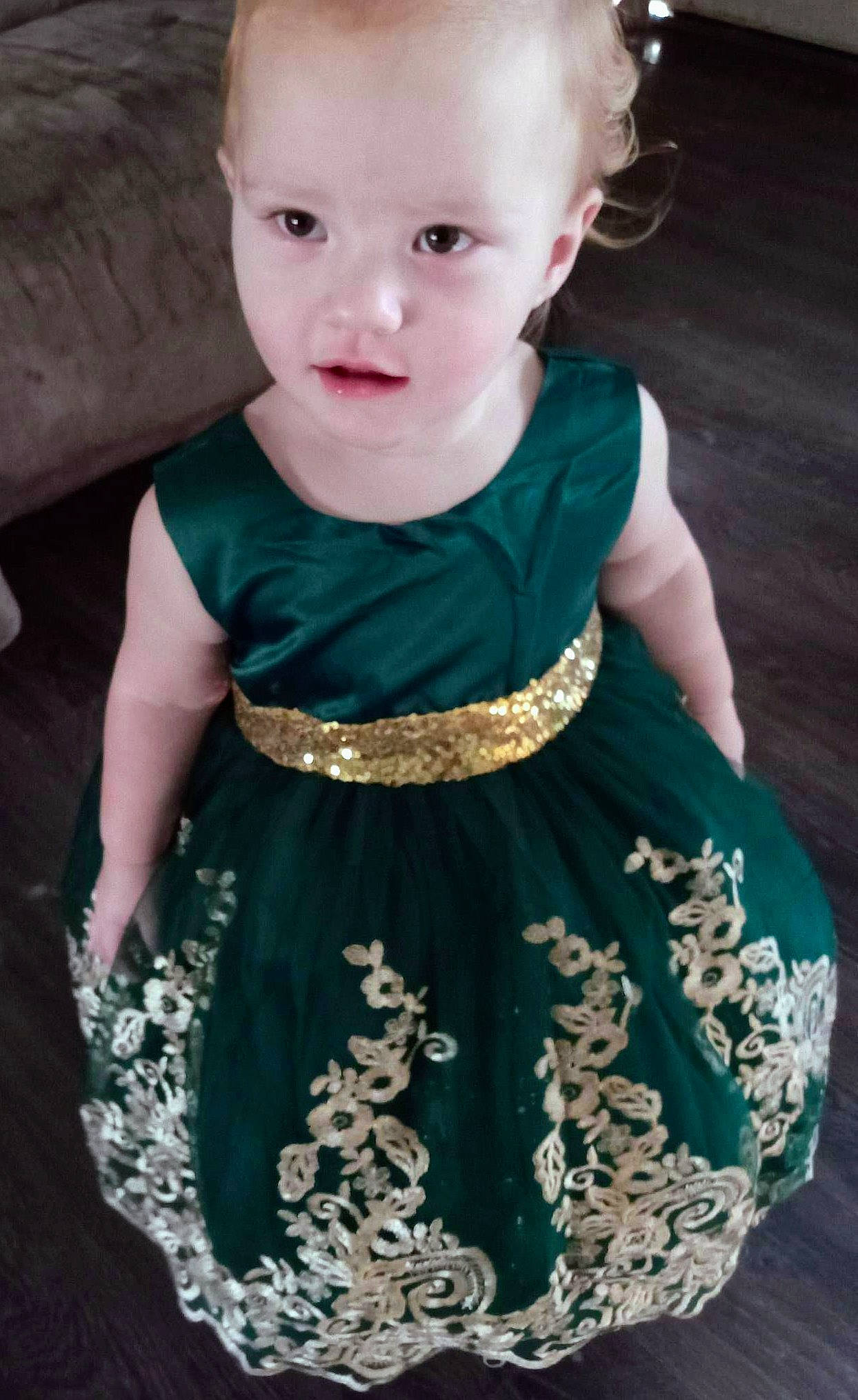 Paislyn is registered to the contest to win money with this photo: aqua, baby_toddler_clothing, black, clothing, day_dress, dress, green, hair, head, neck, one_piece_garment, person, photograph, pink, shoulder, skin, sleeve, standing, toddler, waist
