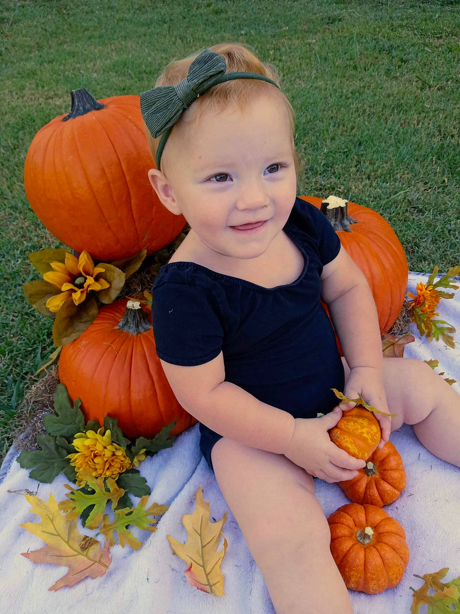 Paislyn joined the competition — help win amazing prizes! baby_toddler_clothing, calabaza, cucurbita, face, gourd, grass, happy, head, human_body, iris, joy, leaf, natural_foods, orange, people_in_nature, person, plant, pumpkin, smile, squash