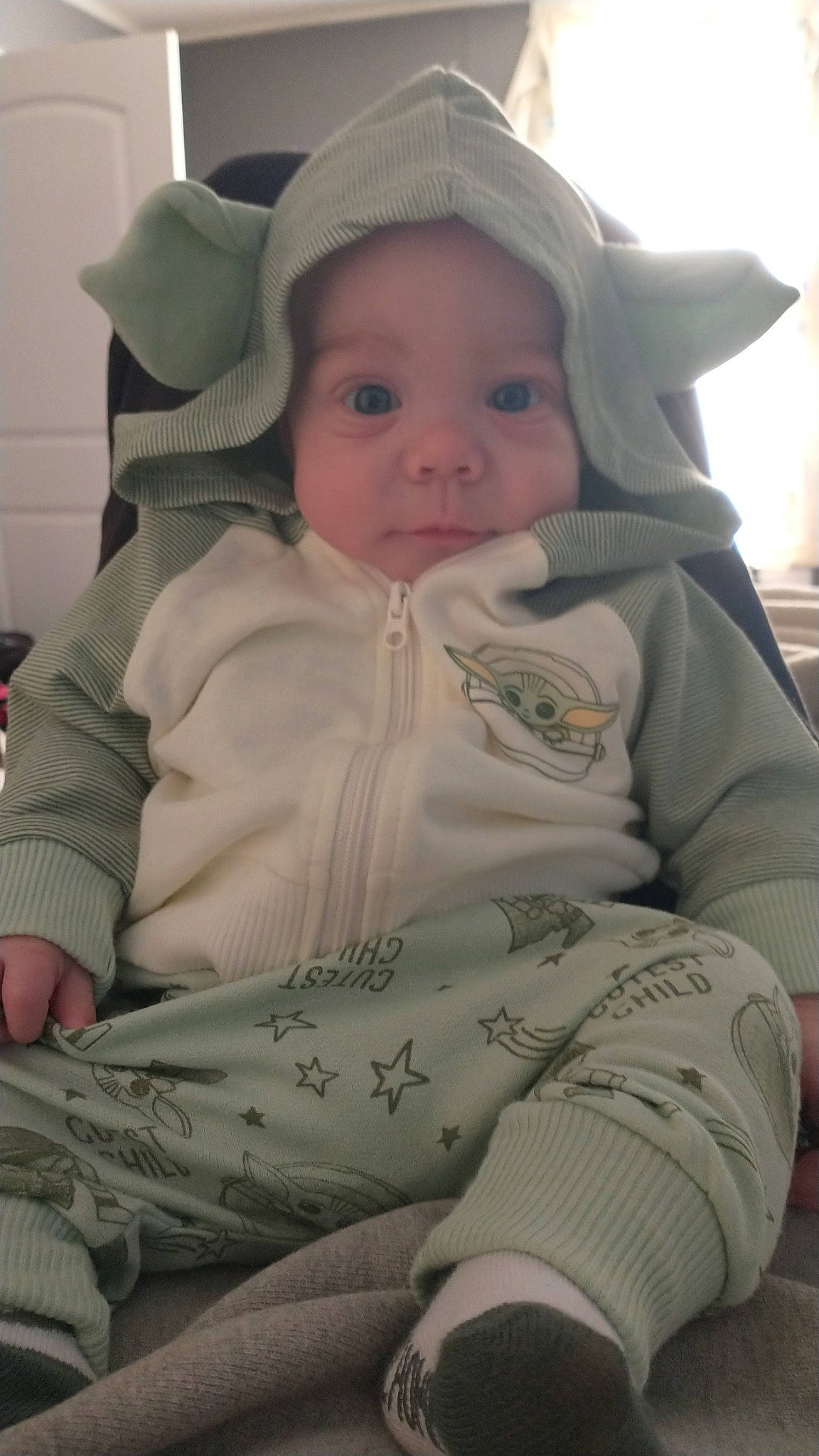 Brett is registered to the contest to win money with this photo: baby, baby_products, baby_toddler_clothing, cheek, child, comfort, eye, foot, fur, grass, happy, headwear, iris, lip, nose, pattern, person, sitting, skin, sleeve