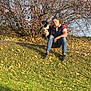 Lucky participe au concours pour gagner de l'argent avec cette photo : man, dog, grass, autumn, leaves, tree, outdoor, sitting, casual, friendship, nature, pet, smile, daylight, jeans, shirt, black_dog, white_dog, relaxation, companionship