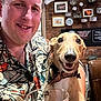 Murphy joined the competition — help win amazing prizes! man, dog, smiling, portrait, indoor, cafe, brick_wall, collar, glass, decor, framed_picture, patterned_shirt, happy, seated, pet, leisure, casual, light, face, table