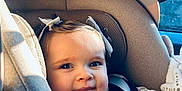 Mila a rejoint le concours — aidez-le/la à gagner de superbes lots ! baby, child, car_seat, seatbelt, bow, smile, face, infant, sunlight, window, clothing, cute, happy, indoors, person, portrait, seat, car, young, baby_clothes