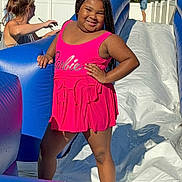 Alixandria is registered to the contest to win money with this photo: backyard, barbie, child, fence, fun, girl, happy, inflatable, outdoor, person, pink, play, smile, summer, sunlight, swimsuit, tree, water, water_slide, woman