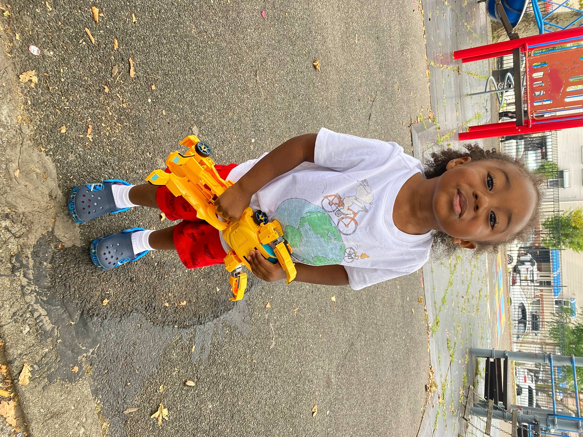 Carlos is registered to the contest to win money with this photo: adaptation, asphalt, child, city, concrete, fun, human_settlement, leisure, person, plastic, play, recreation, road, road_surface, shadow, sidewalk, soil, street, t_shirt, tar