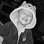 child, toddler, smiling, hood, jacket, indoor, black_and_white, portrait, happy, cute, baby, clothing, face, person, expression, young_child, cozy, funny, cute_outfit, joy