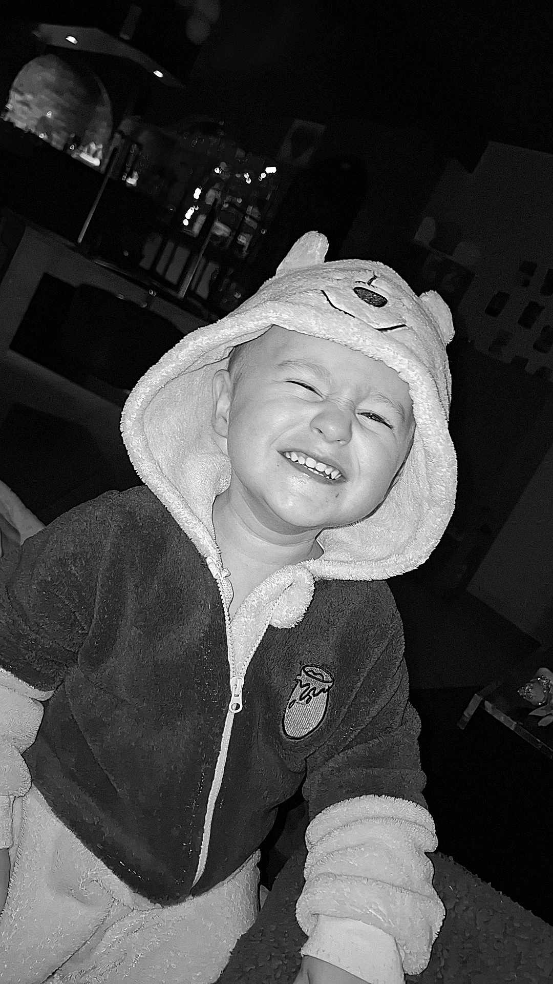 Jayden participe au concours pour gagner de l'argent avec cette photo : child, toddler, smiling, hood, jacket, indoor, black_and_white, portrait, happy, cute, baby, clothing, face, person, expression, young_child, cozy, funny, cute_outfit, joy