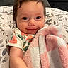 Alayna is registered to the contest to win money with this photo: baby, infant, child, smiling, face, portrait, lying_down, blanket, pink_blanket, bedding, pillow, fluffy, onesie, fruit_pattern, home, indoors, cozy, happy, close_up, photography