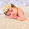 Zarnab is registered to the contest to win money with this photo: baby, infant, flower_headband, blanket, sleepy, cute, portrait, soft_lighting, resting, skin, newborn, closeup, head, face, peaceful, hands, lying_down, decorative, texture, warm_colors