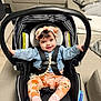 baby, car_seat, headband, smiling, child, indoor, clothing, socks, couch, pillow, blanket, seatbelt, infant, happy, person, furniture, cute, toddler, home, comfort