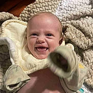 Tilly-Mae is registered to the contest to win money with this photo: baby, blanket, child, clothing, cozy, cute, expression, face, hand, happy, indoors, infant, lying_down, newborn, playful, portrait, skin, smiling, soft, warm