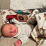 baby, newborn, sleeping, blanket, couch, pillow, holiday, christmas, red_truck, infant, clothing, cozy, resting, soft, home, decor, peaceful, face, person, indoors