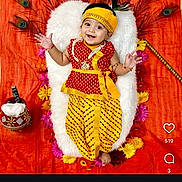 Ayaan is registered to the contest to win money with this photo: baby, child, traditional_clothing, yellow, red, peacock_feathers, flowers, orange_background, smiling, cushion, festive, lying_down, headband, bracelet, portrait, indian_culture, celebration, decor, happy, infant