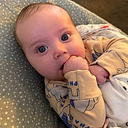 Louie joined the competition — help win amazing prizes! baby, infant, face, hand, pajamas, blanket, cushion, polka_dot, blue_eyes, cute, child, indoors, soft_lighting, comfort, lying_down, skin, person, young, sleepwear, close_up