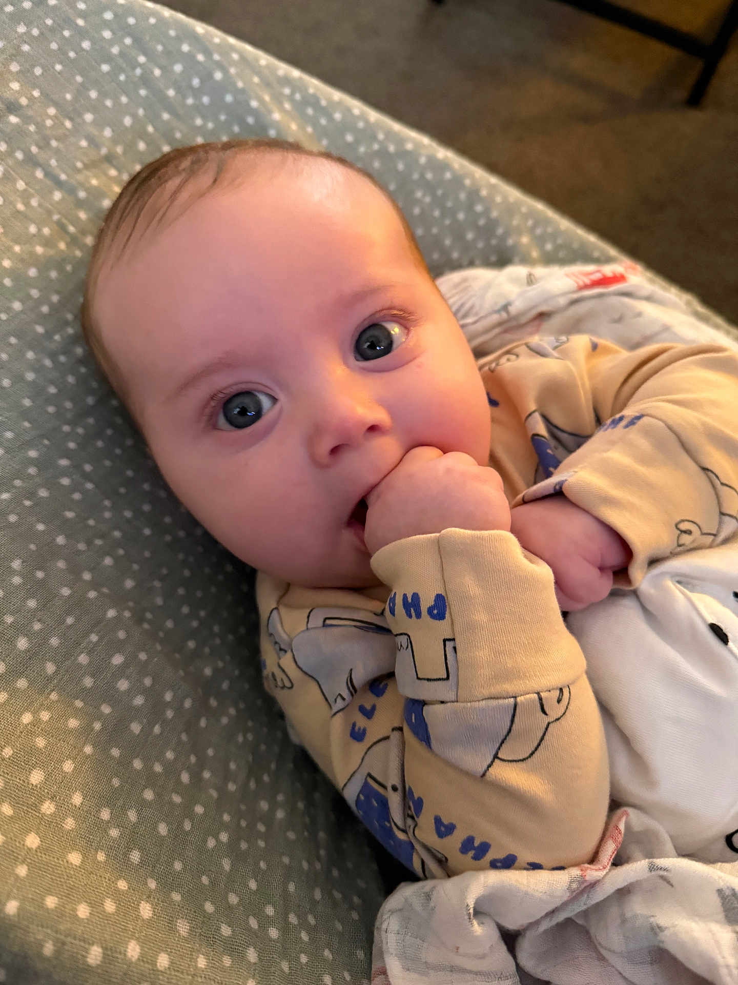 Louie joined the competition — help win amazing prizes! baby, infant, face, hand, pajamas, blanket, cushion, polka_dot, blue_eyes, cute, child, indoors, soft_lighting, comfort, lying_down, skin, person, young, sleepwear, close_up