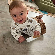 Mattia participe au concours pour gagner de l'argent avec cette photo : baby, smiling, toy, floor, teddy_bear, play_mat, indoor, child, happy, cute, clothing, person, infant, wooden_toy, head, eyes, mouth, hand, legs, home