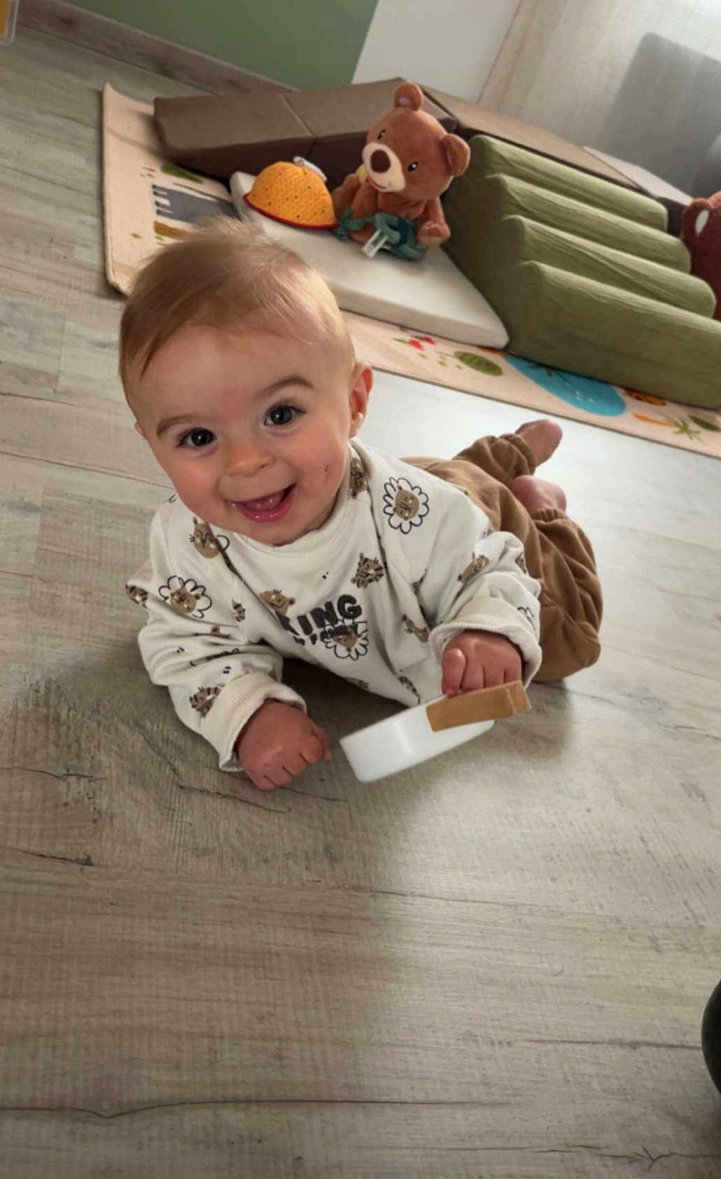 Mattia participe au concours pour gagner de l'argent avec cette photo : baby, smiling, toy, floor, teddy_bear, play_mat, indoor, child, happy, cute, clothing, person, infant, wooden_toy, head, eyes, mouth, hand, legs, home