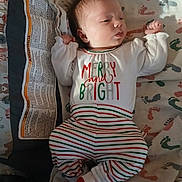 Chloe joined the competition — help win amazing prizes! baby, infant, pajamas, clothing, footprint_pattern, blanket, sleepwear, child, cute, newborn, portrait, person, lying_down, indoors, soft_lighting, striped_pants, white_socks, holiday_theme, sleepy, cozy