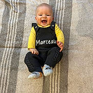 Marceau participe au concours pour gagner de l'argent avec cette photo : baby, casual, child, cozy, cute, happy, indoor, infant, knitted_clothing, lying_down, person, playful, portrait, relaxed, smiling, socks, soft_texture, striped_blanket, yellow_shirt, young_child