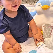 Zaaviar participe au concours pour gagner de l'argent avec cette photo : toddler, child, baby, cap, sneakers, plush_toy, penguin, blanket, smiling, happy, indoor, cute, playing, footwear, sock, bracelet, card, number, sitting, person