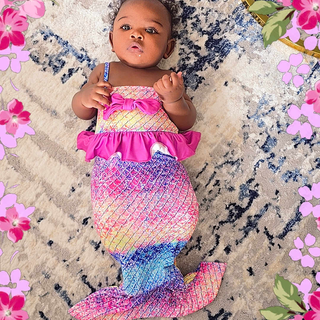 Anahya a rejoint le concours — aidez-le/la à gagner de superbes lots ! adorable, baby, carpet, child, clothing, colorful, costume, cute, decorative, fantasy, floral_border, indoor, infant, lying_down, mermaid_costume, patterned_rug, pink, playful, portrait, purple