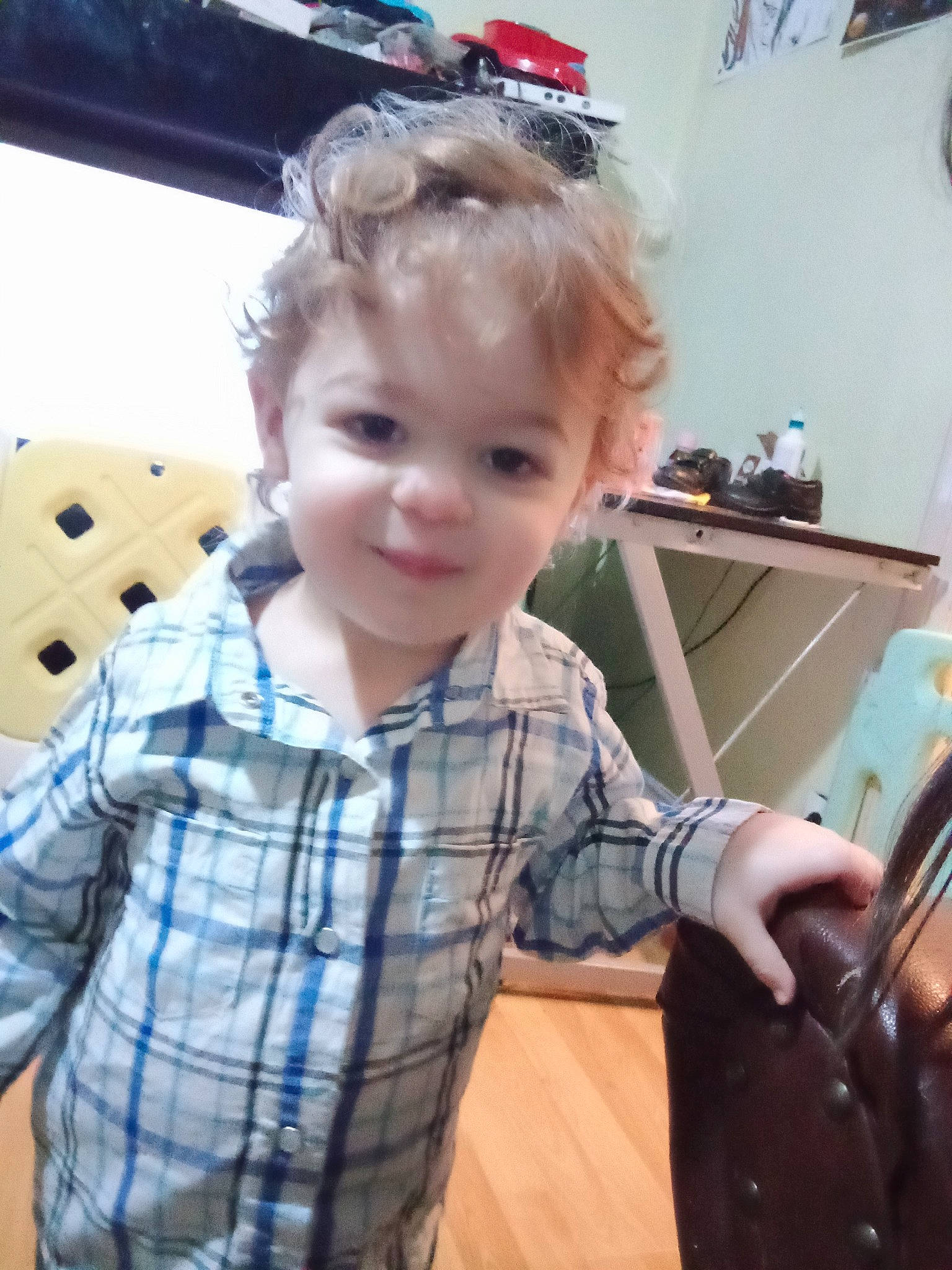 Joris participe au concours pour gagner de l'argent avec cette photo : chair, child, drawer, eyewear, flooring, fun, pattern, person, picture_frame, plaid, play, room, sitting, sleeve, smile, t_shirt, tartan, thumb, toddler, vacation