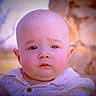 Cyrus is registered to the contest to win money with this photo: baby, bunny_prints, child, closeup, cute, daylight, face, head, innocent, nature, outdoor, person, portrait, serious_expression, shirt, skin, stone_wall, tree, young, young_child