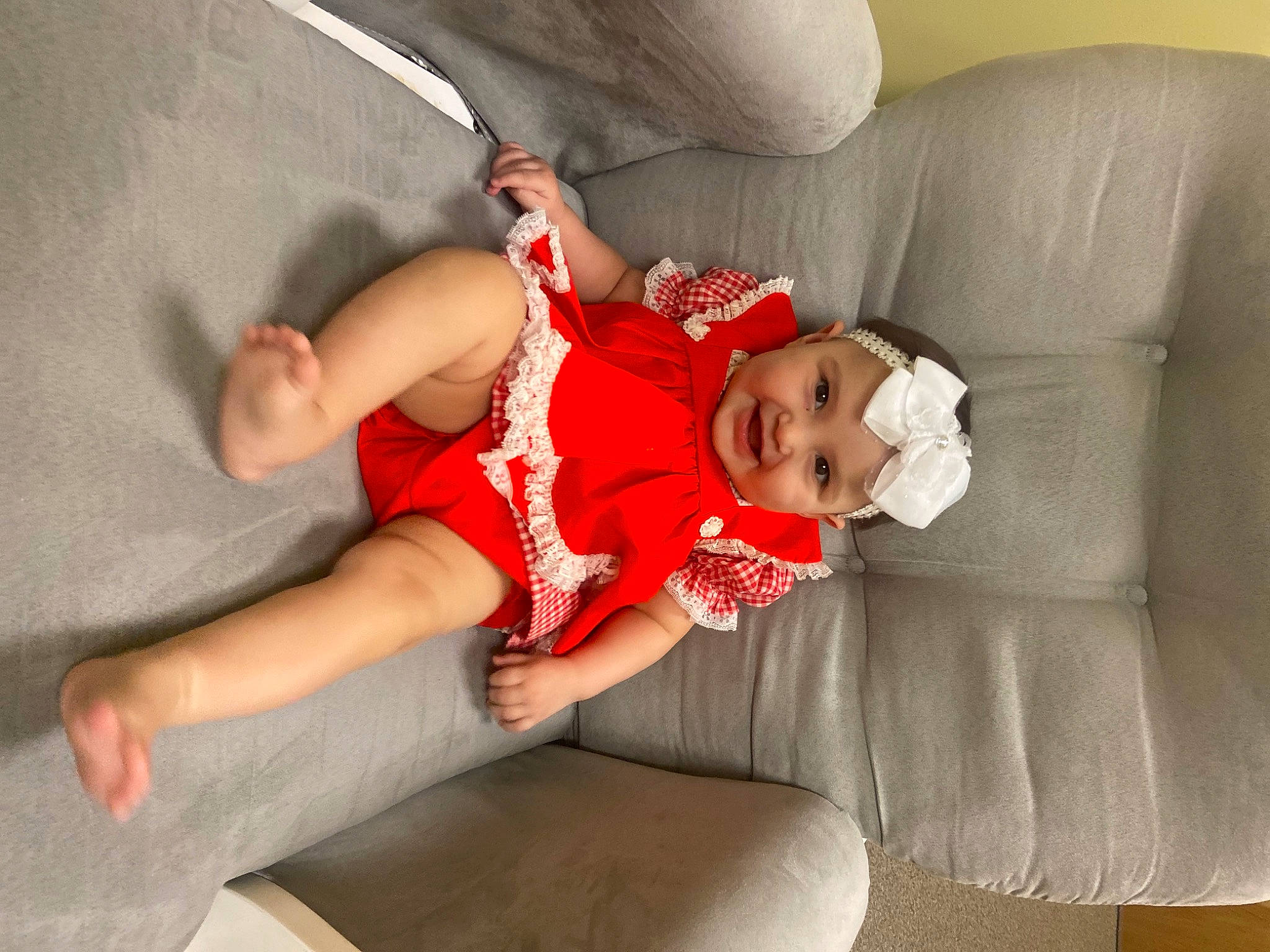 Isabel is registered to the contest to win money with this photo: abdomen, baby, baby_toddler_clothing, carmine, child, comfort, couch, elbow, foot, fun, headwear, human_leg, joy, knee, lap, person, room, shorts, sitting, sock
