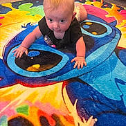 Alina is registered to the contest to win money with this photo: baby, child, crawling, carpet, colorful, cartoon, indoor, dog, animal, floor, person, diaper, shirt, pet, living_room, furniture, cute, playful, young_child, carpet_design