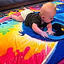 Alina is registered to the contest to win money with this photo: baby, infant, diaper, black_shirt, colorful_blanket, floor, couch, carpet, indoor, child, toddler, lying_down, hands, head, face, skin, furniture, pattern, colorful, exploring
