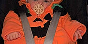 Océane participe au concours pour gagner de l'argent avec cette photo : baby, blanket, booties, car_seat, child, clothing, comfort, cute, face, hat, indoor, infant, mittens, orange_outfit, pacifier, plant, pumpkin_costume, safety_harness, seat, window