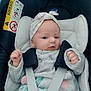 baby, car_seat, infant, headband, blanket, clothing, safety_harness, indoors, child, cute, face, person, seat, comfort, pink, white, soft, newborn, expression, resting