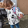 toddler, child, jacket, minnie_mouse, backpack, jeans, shoes, concrete, stroller, hair, pony_tail, outdoor, door, wall, sidewalk, cute, walking, playful, person, young_child