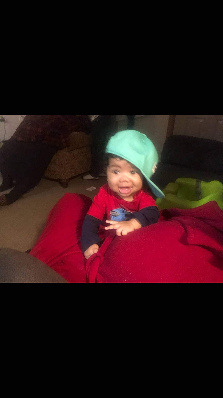 Sebashtian is registered to the contest to win money with this photo: baby, baseball_cap, cap, car_seat, carmine, cloud, comfort, electric_blue, flash_photography, fun, happy, headwear, jacket, knit_cap, magenta, person, personal_protective_equipment, sitting, sleeve, smile