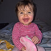 Victoire participe au concours pour gagner de l'argent avec cette photo : baby, bed, blanket, child, clothing, cute, face, hair, hand, happy, home, indoor, person, pink_shoe, portrait, sitting, smiling, striped_shirt, toddler, toy