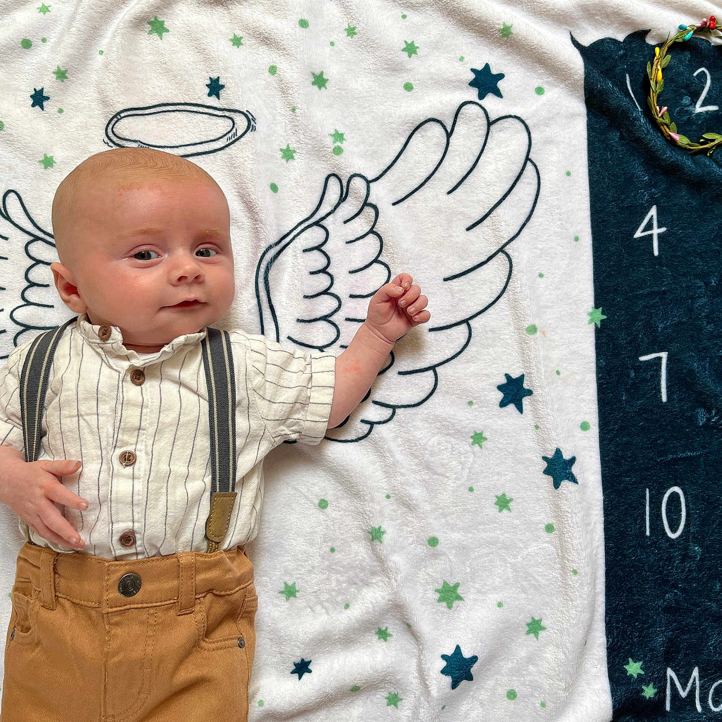 Naël a rejoint le concours — aidez-le/la à gagner de superbes lots ! adorable, angel_wings, baby, baby_milestone, blanket, child, clothing, cute, infant, lying_down, milestone_tracker, numbers, pants, portrait, smiling, soft_texture, stars, striped_shirt, suspenders, wreath