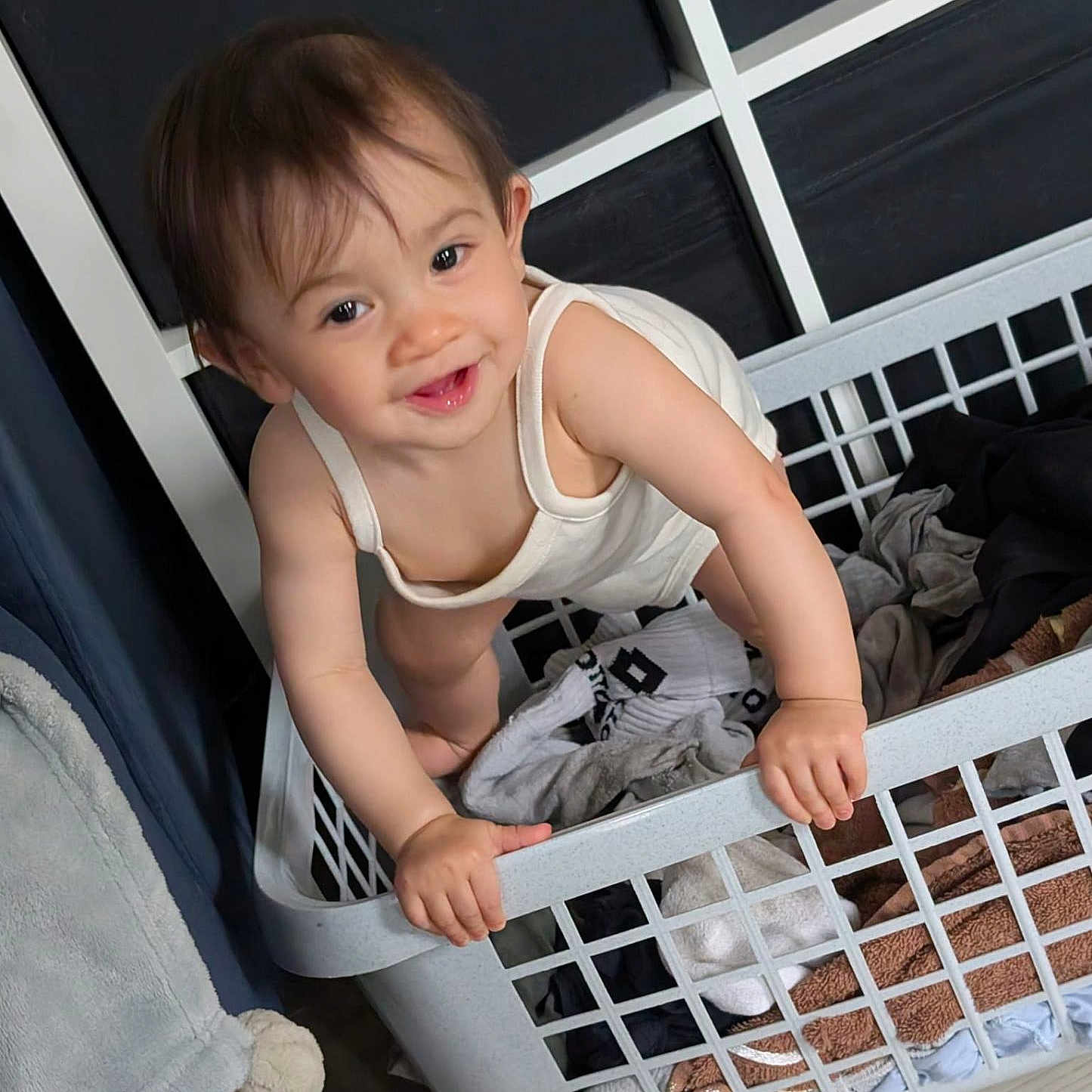 Melody Ai-Ling participe au concours pour gagner de l'argent avec cette photo : baby, basket, child, clothes, curly_hair, cute, expression, fabric, floor, furniture, hands, household, indoor, laundry_basket, person, playful, smile, toddler, white_clothing, young_child