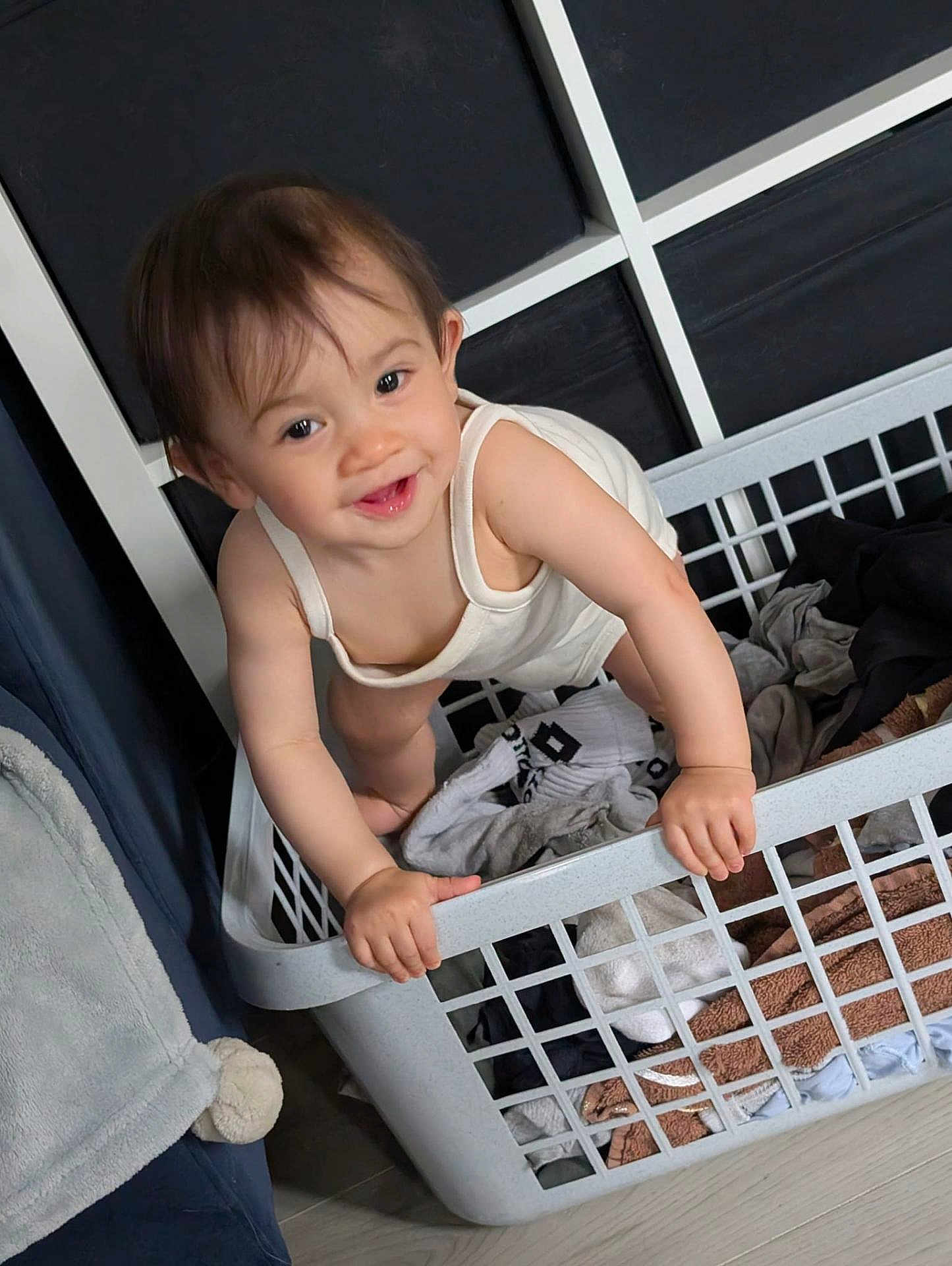 Melody Ai-Ling participe au concours pour gagner de l'argent avec cette photo : baby, basket, child, clothes, curly_hair, cute, expression, fabric, floor, furniture, hands, household, indoor, laundry_basket, person, playful, smile, toddler, white_clothing, young_child