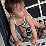 baby, basket, casual, child, clothes, curious, fabric, face, hair, hands, home, indoor, laundry_basket, looking_away, skin, soft_lighting, standing, toddler, white_onesie, young_child