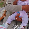 baby, child, infant, person, sneakers, pink_clothing, hand, nail_polish, ring, outdoor, lap, casual, seated, holding, closeup, cute, young_child, fashion, accessory, affection