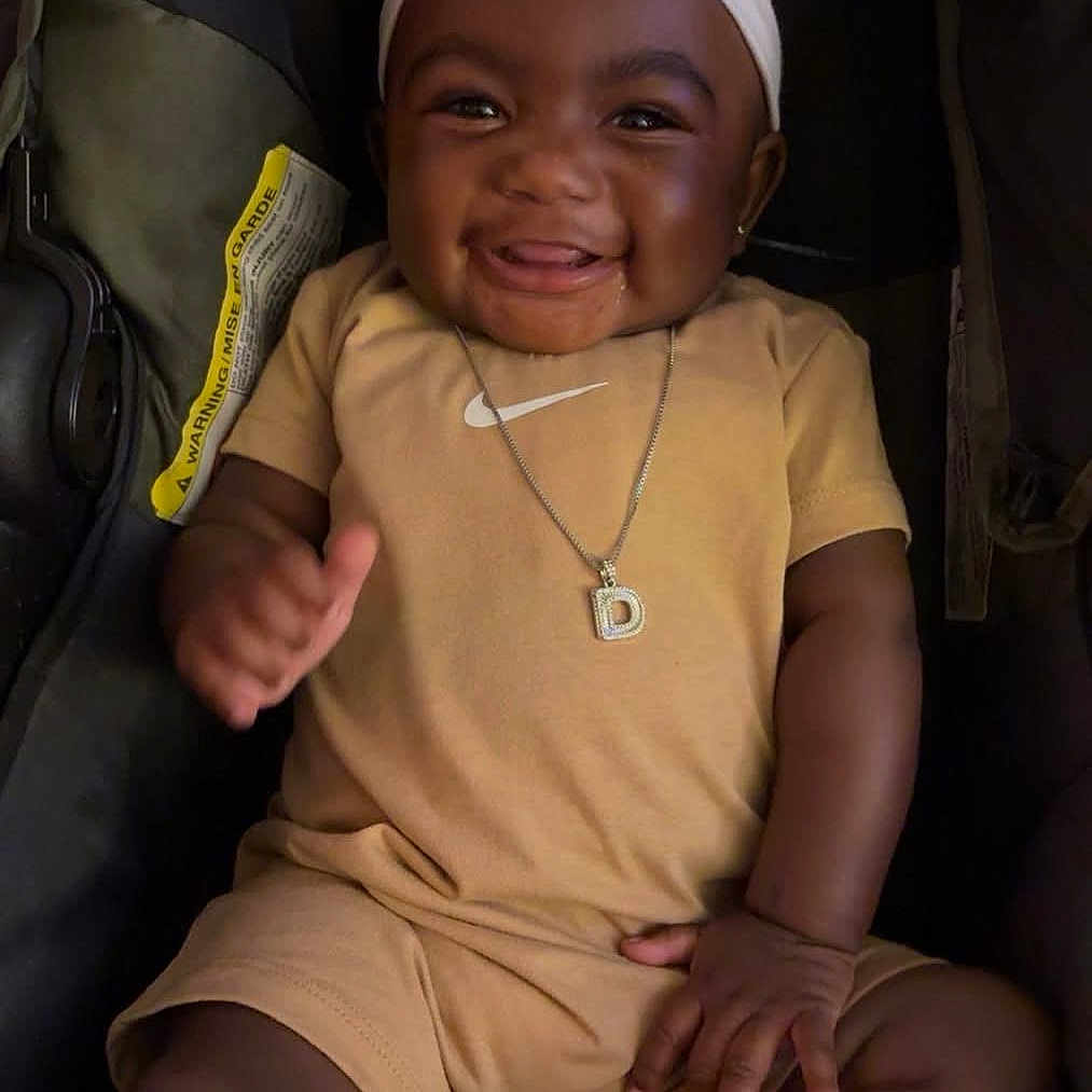 Dream Legacy joined the competition — help win amazing prizes! baby, smiling, child, headband, bow, necklace, clothing, stroller, happy, sitting, infant, cute, portrait, fashion, young_child, person, apparel, casual, one_person, indoors