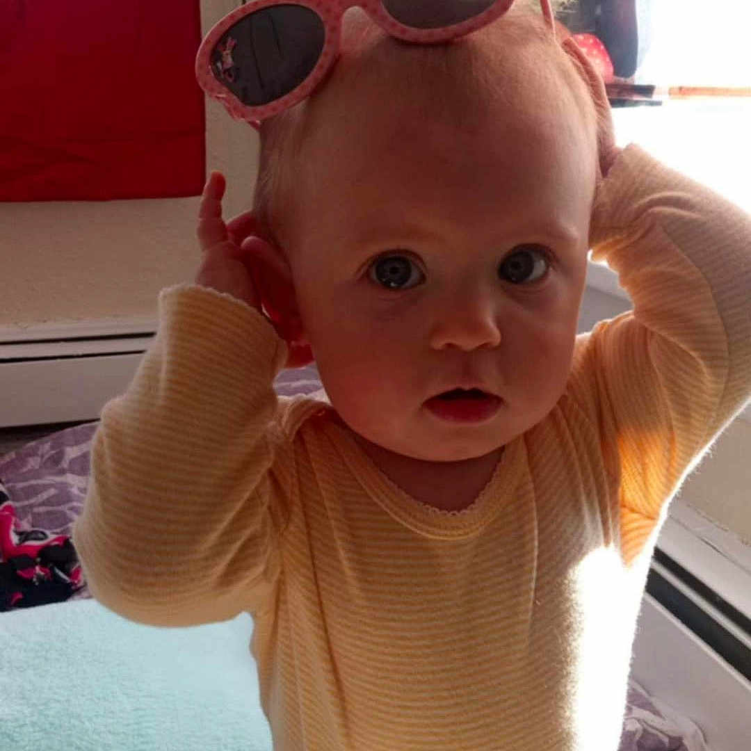Emily joined the competition — help win amazing prizes! accessories, architecture, baby, building, clothing, couch, cushion, face, furniture, glasses, goggles, head, homedecor, indoors, person, photography, portrait, sitting, sunglasses, t_shirt