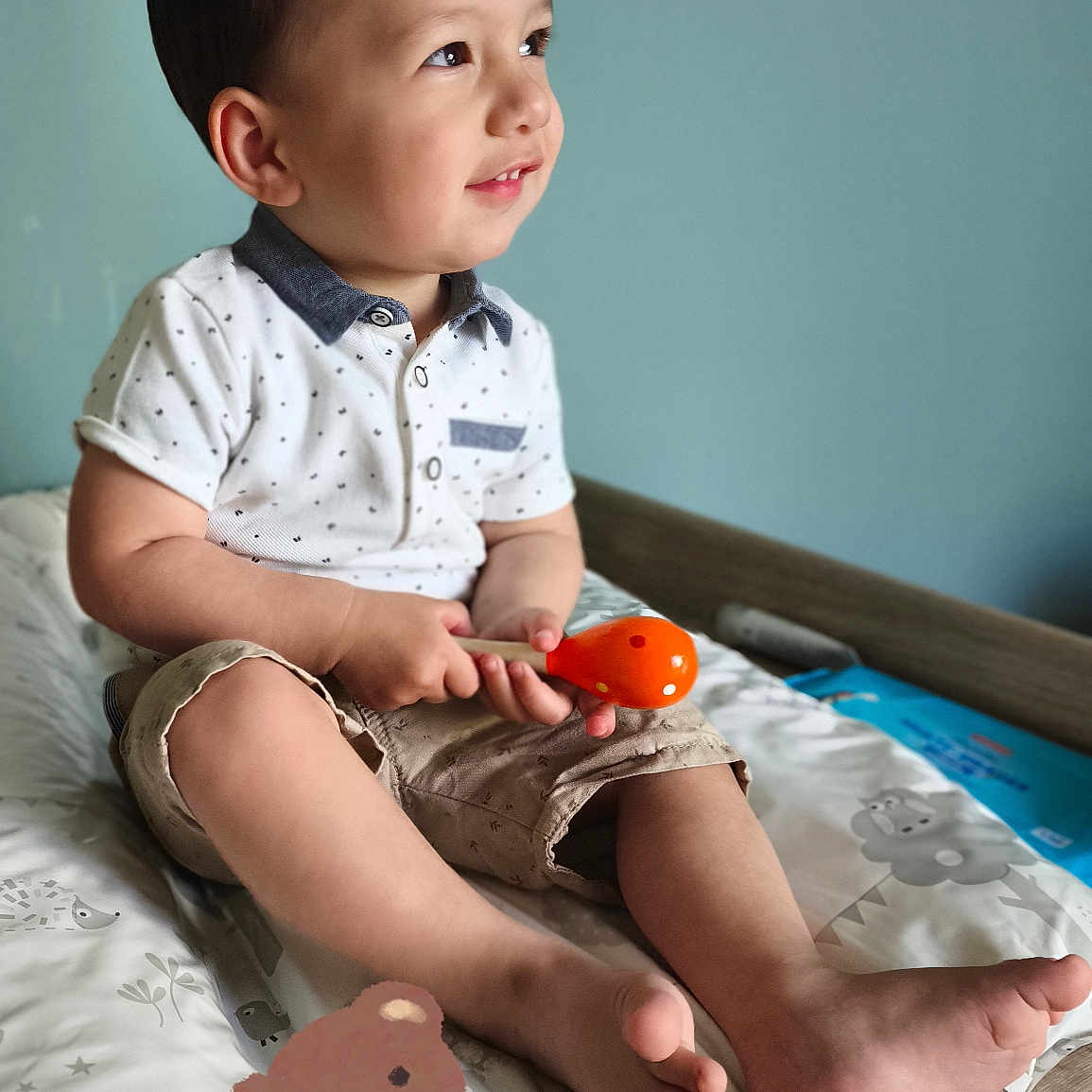 Matheïs participe au concours pour gagner de l'argent avec cette photo : baby, barefoot, beige_shorts, blue_wall, changing_table, child, cute, happy, indoor, infant, maraca, playful, plush_toy, portrait, short_hair, smiling, toddler, toy, white_shirt, wooden_furniture