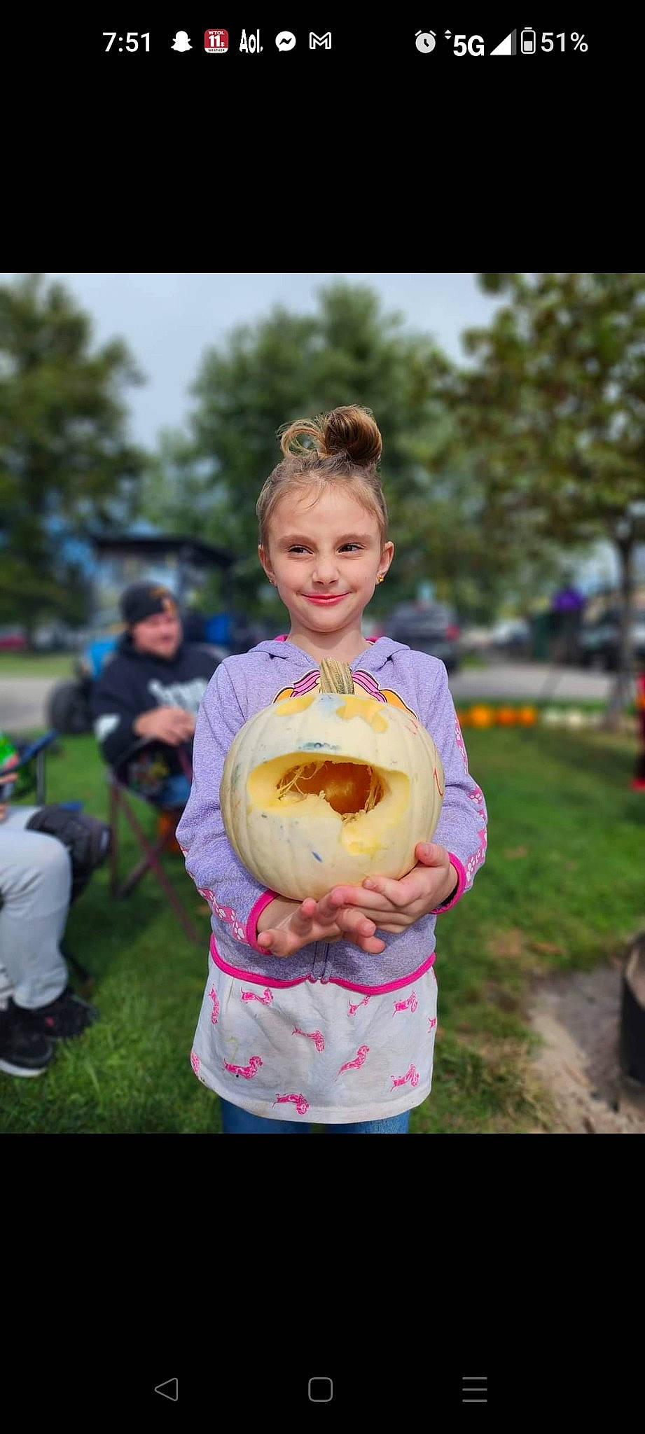 Tina is registered to the contest to win money with this photo: apple, blurred, child, dessert, event, facial_expression, food, fruit, fun, grass, happy, joy, people_in_nature, person, pink, plant, pumpkin, recreation, sky, smile