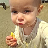 Riley is registered to the contest to win money with this photo: toddler, child, baby, onesie, snack, carpet, indoor, cat, animal, floor, face, hand, expression, person, young_child, clothing, food, home, cute, curious