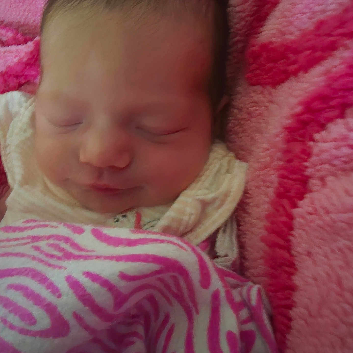 Lilliana is registered to the contest to win money with this photo: baby, newborn, sleeping, blanket, pink, soft, cozy, infant, face, closed_eyes, cute, child, warm, resting, pattern, fabric, portrait, snug, head, peaceful