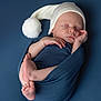 Clément participe au concours pour gagner de l'argent avec cette photo : newborn, baby, sleeping, wrapped, blanket, blue, hat, white_hat, pom_pom, infant, cute, peaceful, portrait, studio, soft_lighting, child, resting, cozy, skin, hands