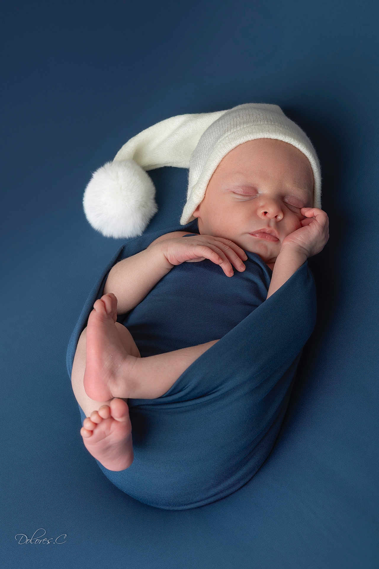 Clément participe au concours pour gagner de l'argent avec cette photo : newborn, baby, sleeping, wrapped, blanket, blue, hat, white_hat, pom_pom, infant, cute, peaceful, portrait, studio, soft_lighting, child, resting, cozy, skin, hands